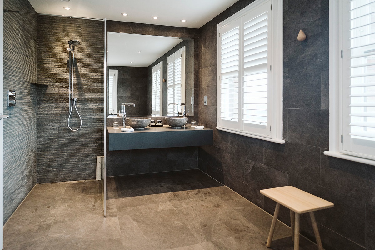 front view of walk-in shower alongside vanity and mirror