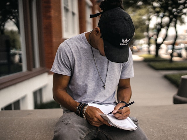 man sitting outside journaling in a notebook