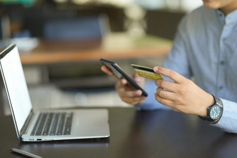 A person using a credit card in front of a computer