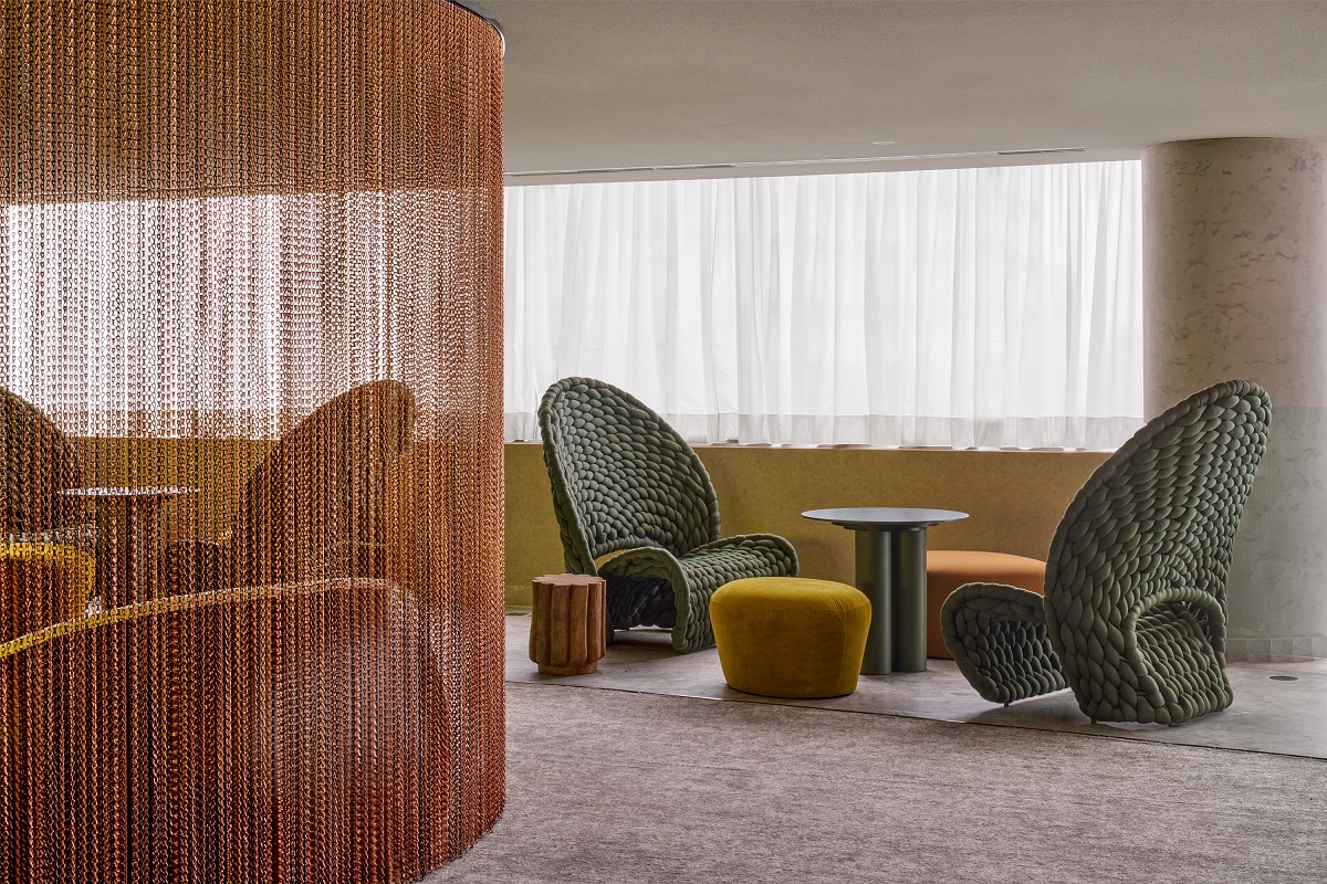 curved chairs and a metal chain curtain in seating area of W São Paulo