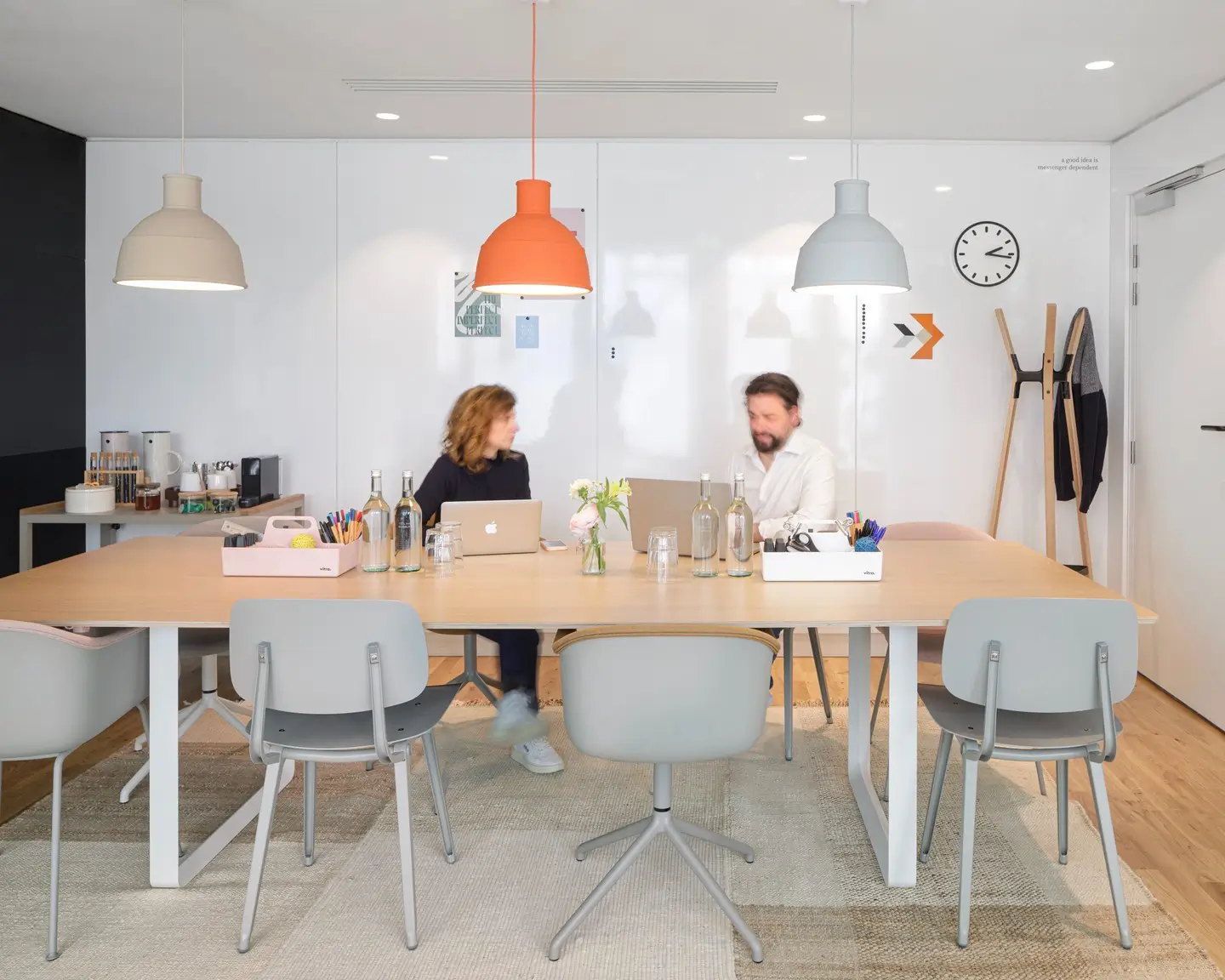 Two individuals engaged in discussion at an office table, focusing on revenue management trends, particularly ancillary revenue.