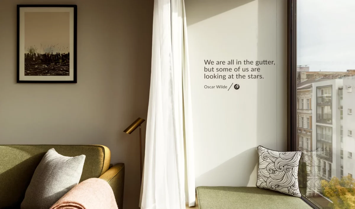 Wilde Aparthotels Berlin Checkpoint Charlie, bedroom with Oscar Wilde quote on wall that reads we are all in the gutter, some of us are just looking at the stars